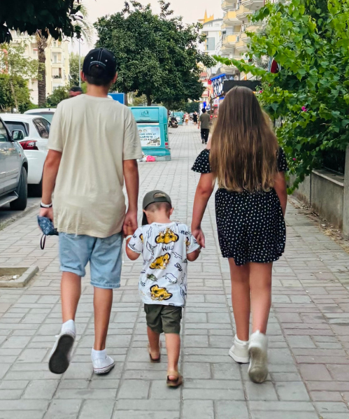 Three children walking down street