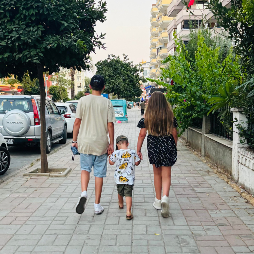 Three children walking down street
