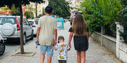 Three children walking down street